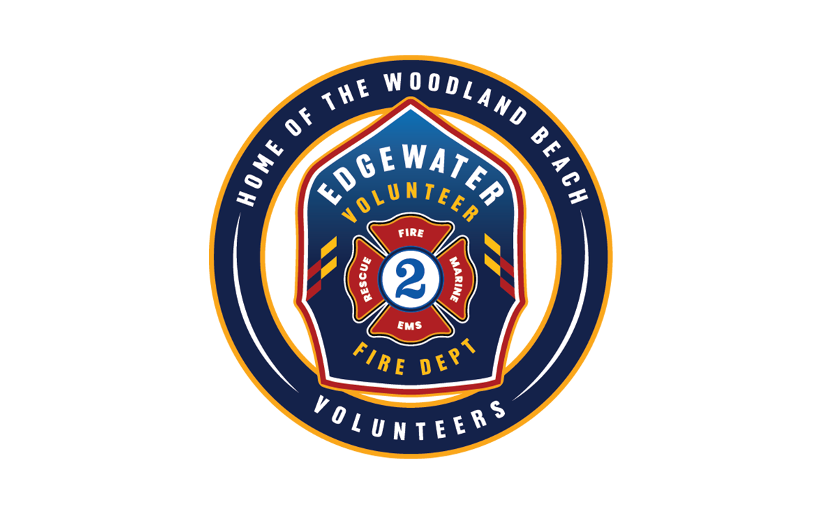 Circular logo for Edgewater Volunteer Fire Dept. Features a firefighter helmet with "Rescue", "EMS", and "Fire" written on it. Text around the logo reads "Home of the Woodland Beach Volunteers.