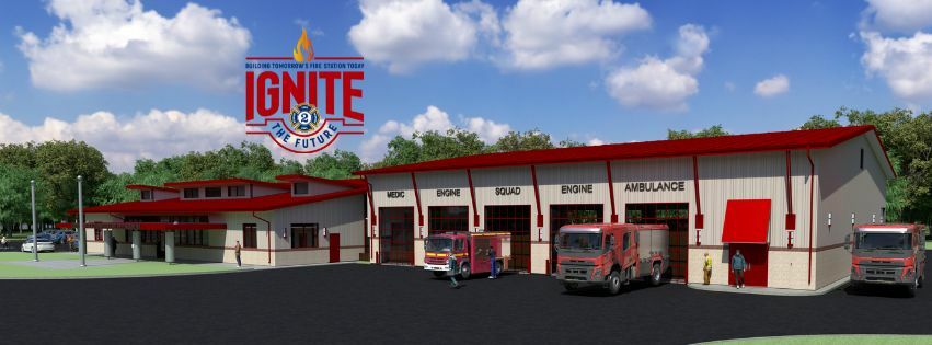 A modern fire station with several red fire trucks parked outside. The building has a sign reading "Ignite the Future" with a fire department logo. The sky is clear blue with a few clouds, and trees are in the background.